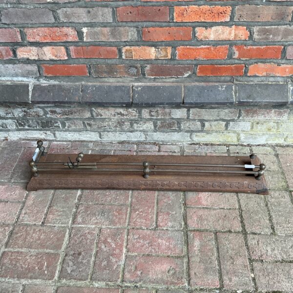 Vintage cast iron and brass fireplace fender for hearth protection.