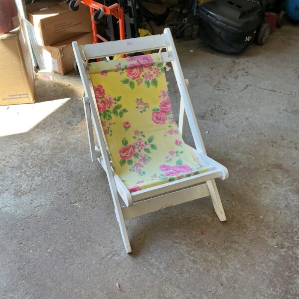 Vintage floral deck chair with wooden frame.