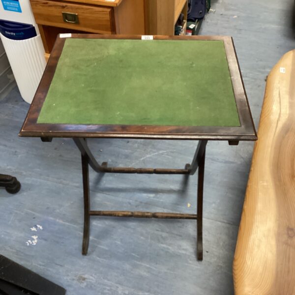 Vintage folding side table with green felt top and tripod legs.