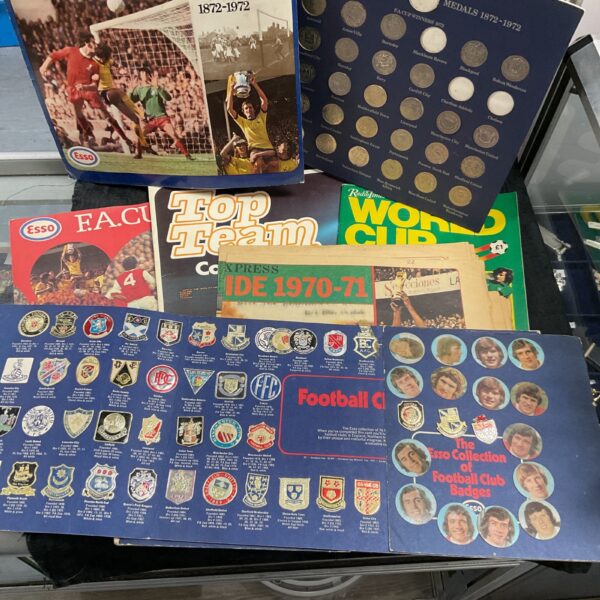 Vintage football memorabilia collection including coins and wall charts.