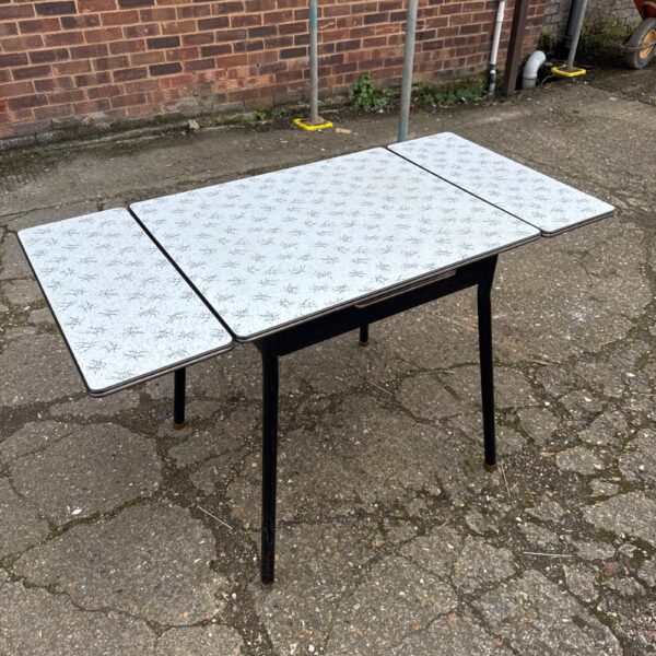 Vintage 1950s Formica table with speckled top and extending leaf.