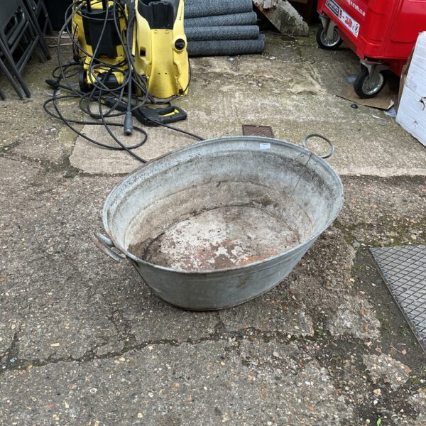 Vintage galvanised bath tub with signs of wear and rust.