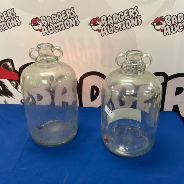 Pair of vintage glass demijohns for fermentation or storage.