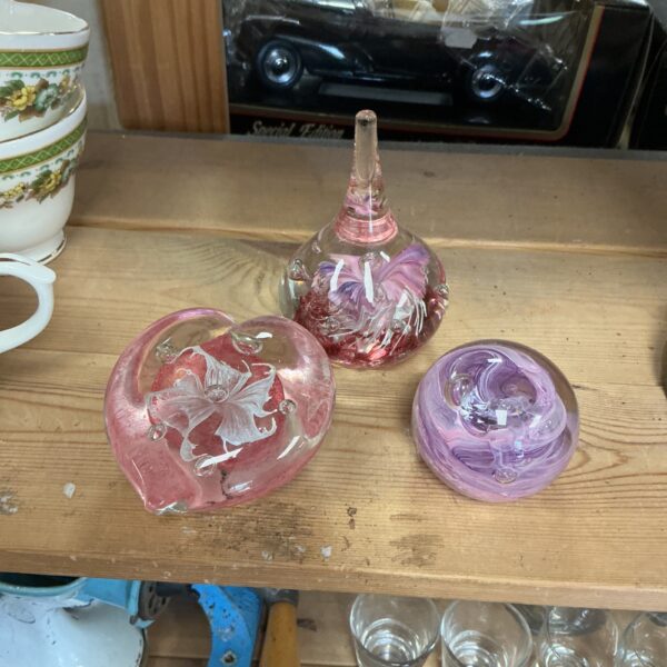 Lot of three vintage glass paperweights with colourful designs.