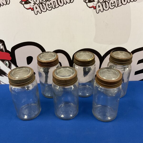 Set of six vintage glass storage jars with metal lids.
