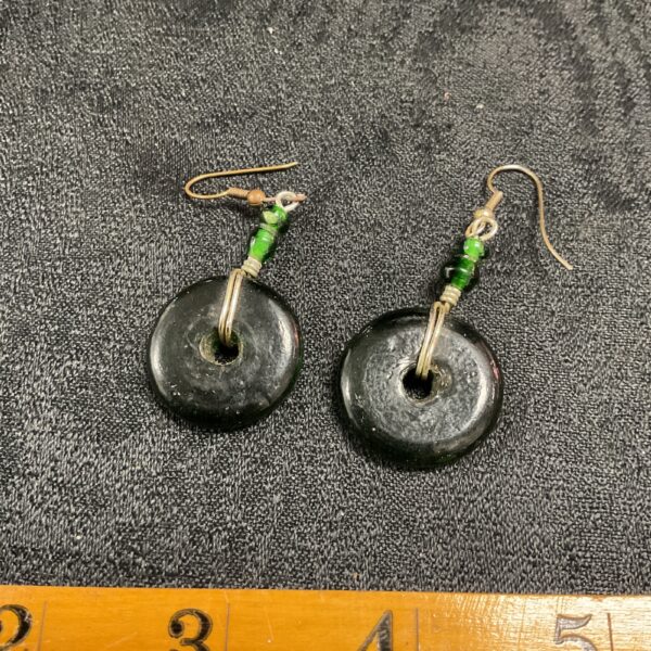 Close-up of vintage green glass dangle earrings.