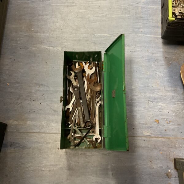 Open vintage green metal tool box with tools inside.
