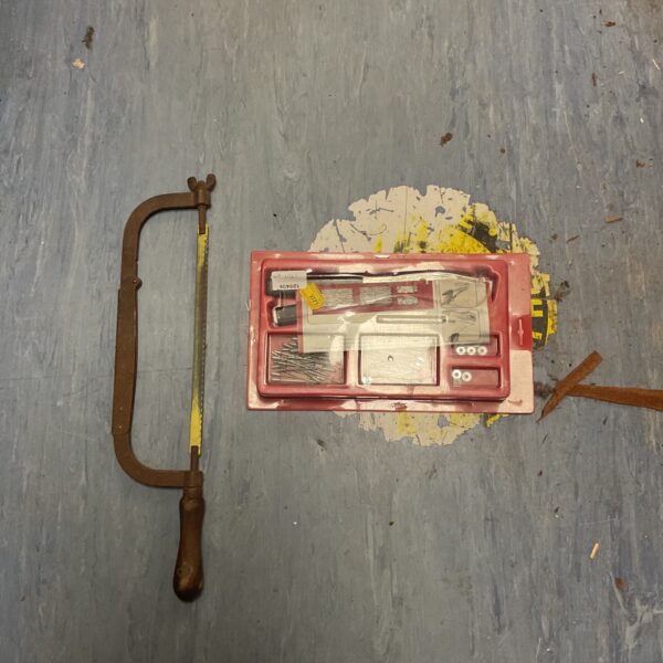 Vintage metal hacksaw with unopened accessory kit for workshop use.