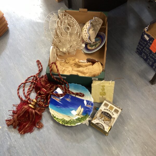 Vintage hanging decorative plates with a nautical scene and red tassel.