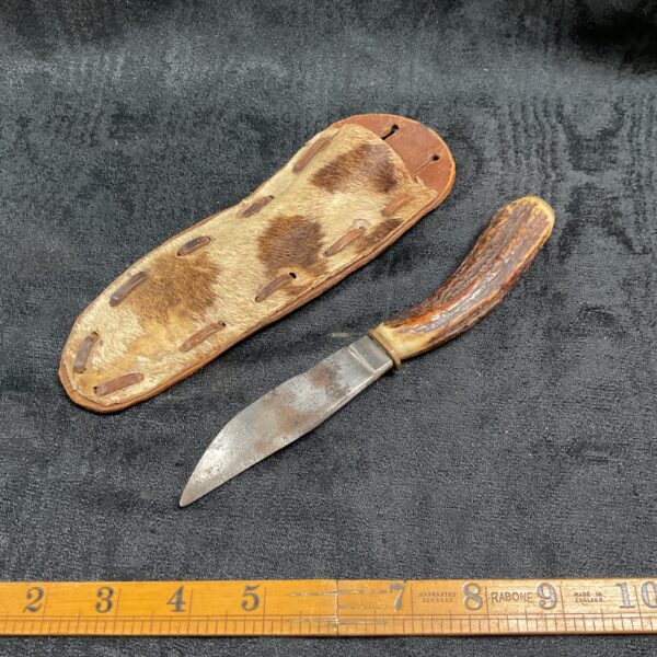 Vintage horn handle knife with leather sheath, antique collectible.
