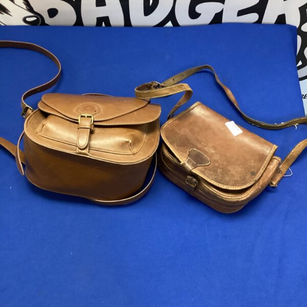 Pair of vintage brown leather satchels on a blue background.