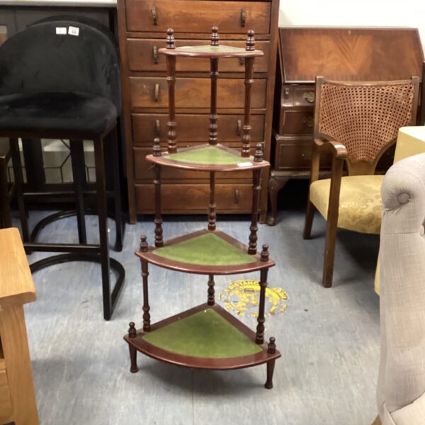 Vintage mahogany corner shelving unit with green leather tiers.