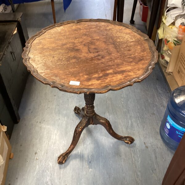 Vintage mahogany pie crust table with three legs.