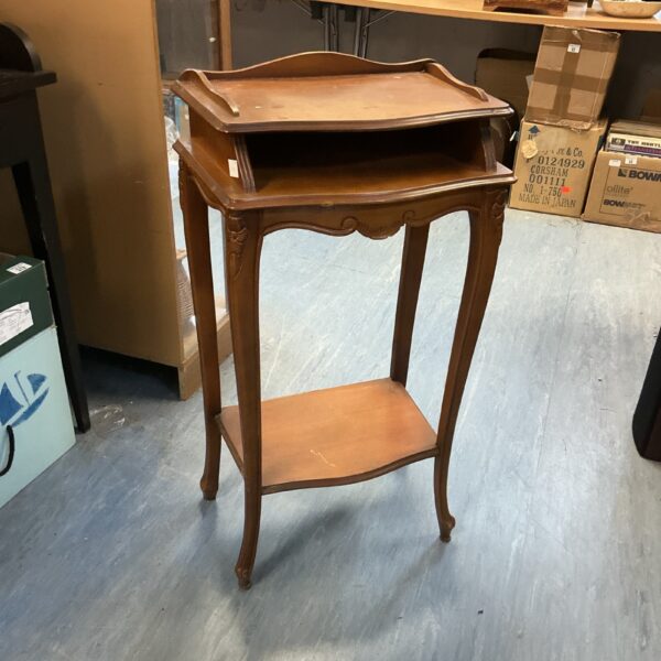 Vintage mahogany telephone table with curved legs and shelf.