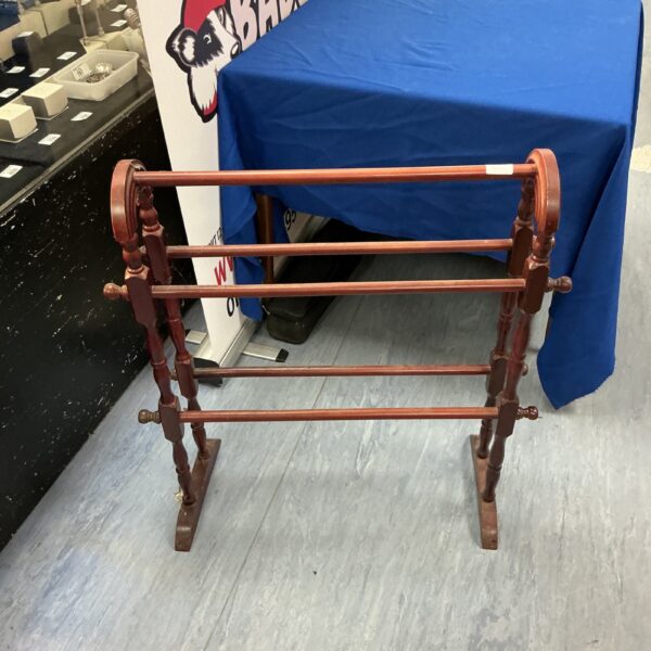 Vintage mahogany towel rail with decorative spindles, ideal for bathroom decor.