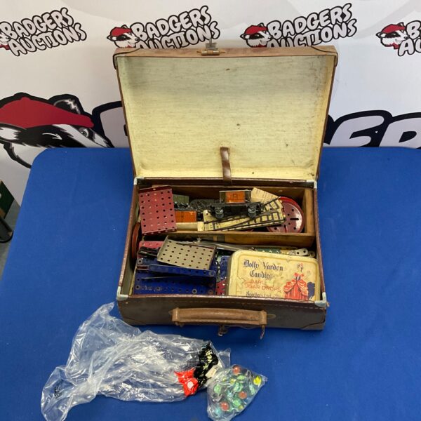 Vintage Meccano set in a weathered carrying case with components visible.