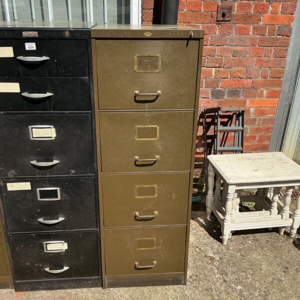 Vintage metal filing cabinet with four drawers, showing signs of wear.