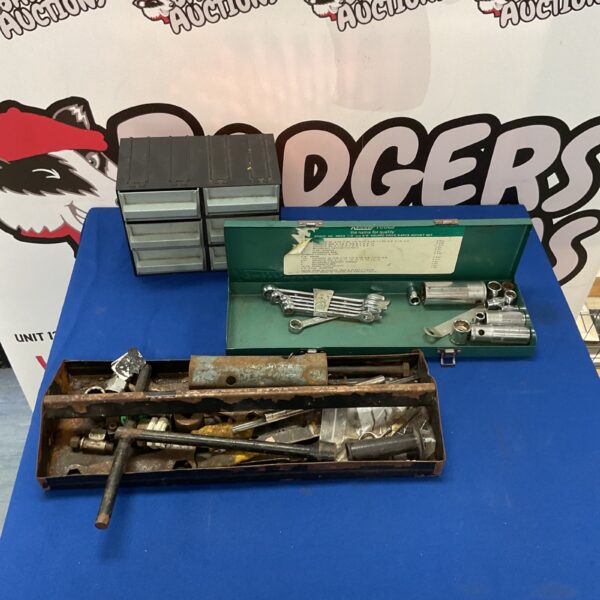 Vintage metal tool storage box with drawers and tools inside.