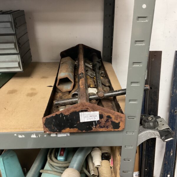 Vintage metal tool tote filled with antique tools for workshop storage.
