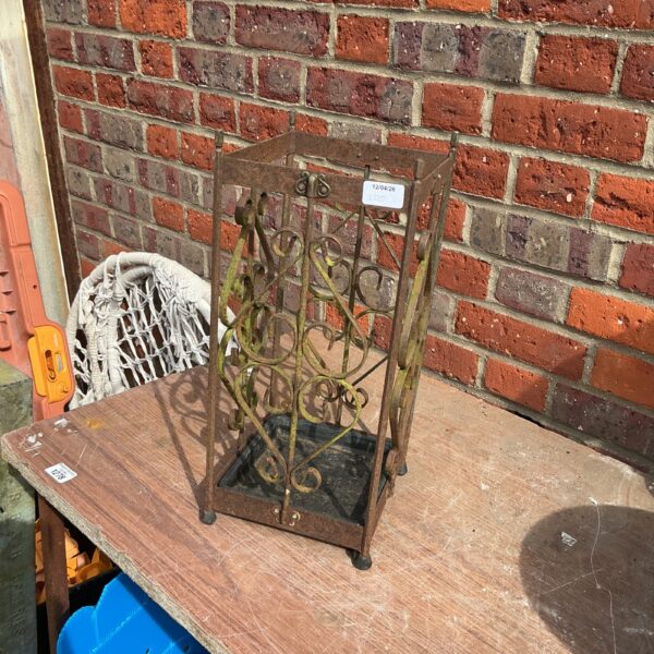 Vintage metal umbrella stand with decorative openwork design.