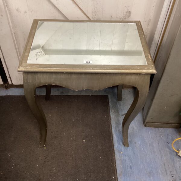 Elegant vintage mirrored side table with curved frame.