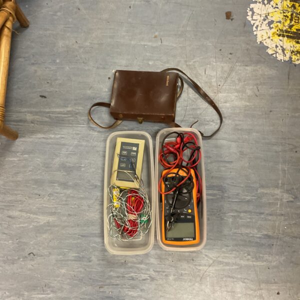 Vintage multimeter and thermometer set in a brown leather case.