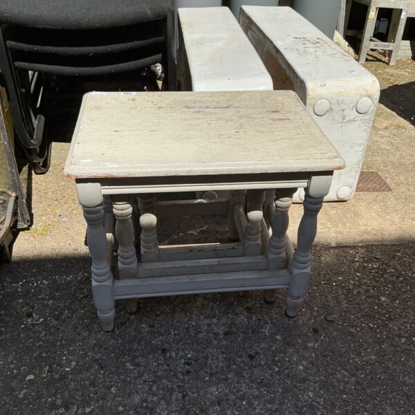 Vintage nest of three painted tables with turned legs.