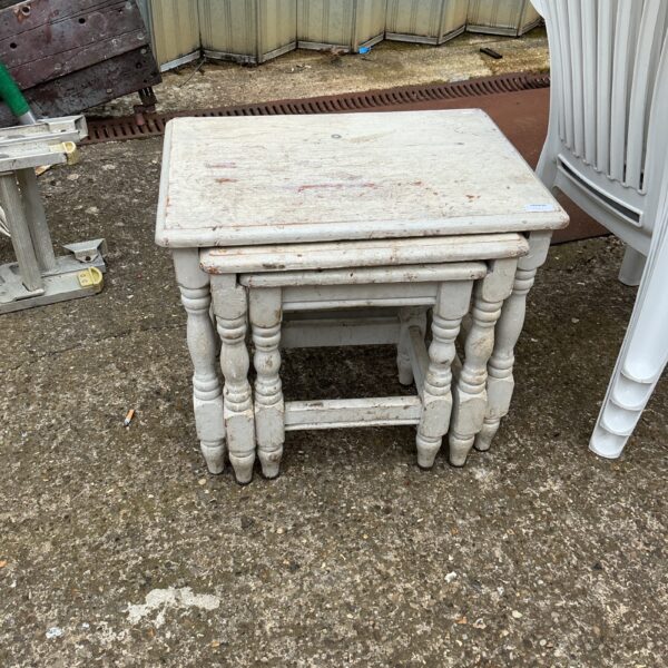 Distressed grey vintage nest of tables in a hallway.