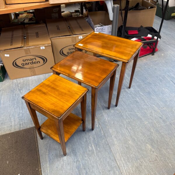 Vintage nest of three wooden side tables in a hall.