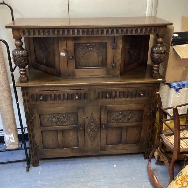 Vintage oak cabinet with detailed carved acorn motifs.