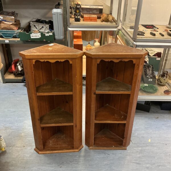 Two vintage oak corner shelf units for display.