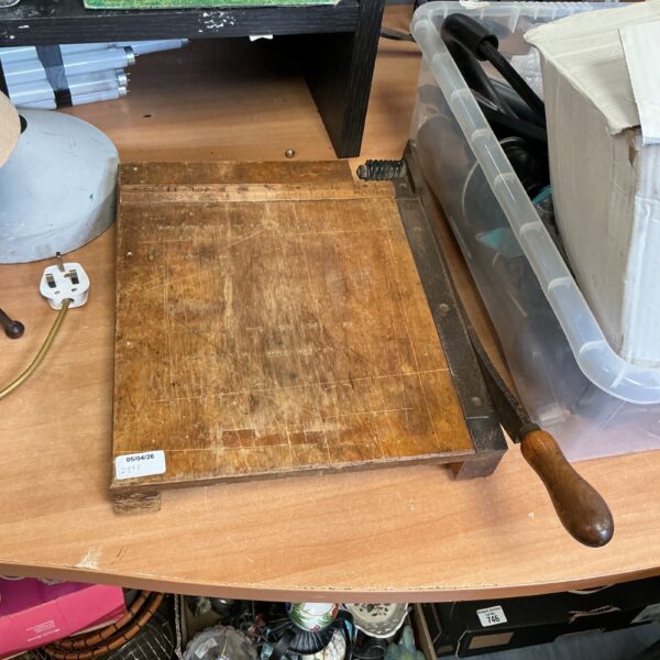 Vintage wooden paper guillotine with wooden handle and metal blade.