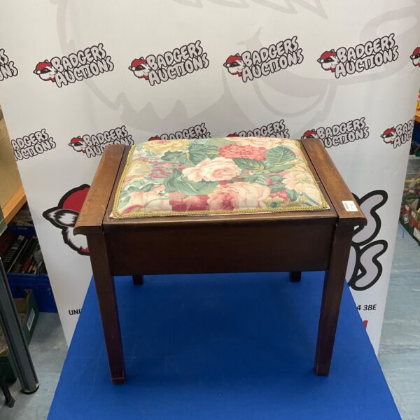 Vintage piano stool with floral upholstery and wooden legs.