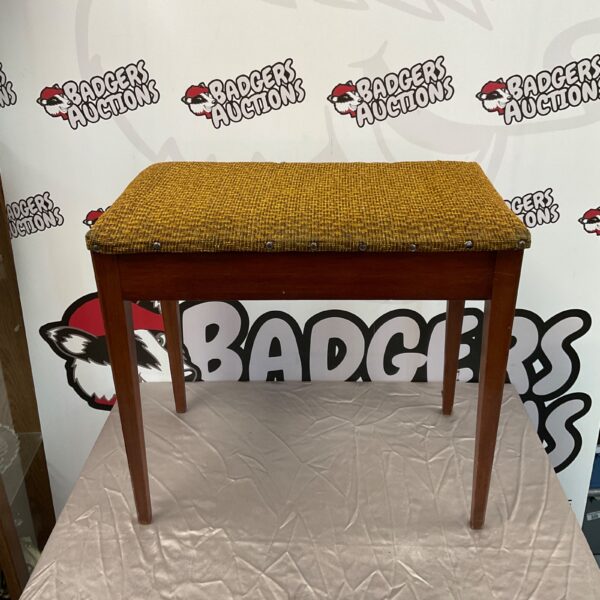 Vintage patterned piano stool with wooden legs.
