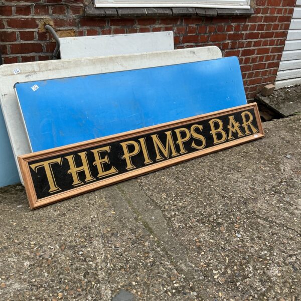 Vintage Pimm’s Bar sign with raised lettering and decorative border.