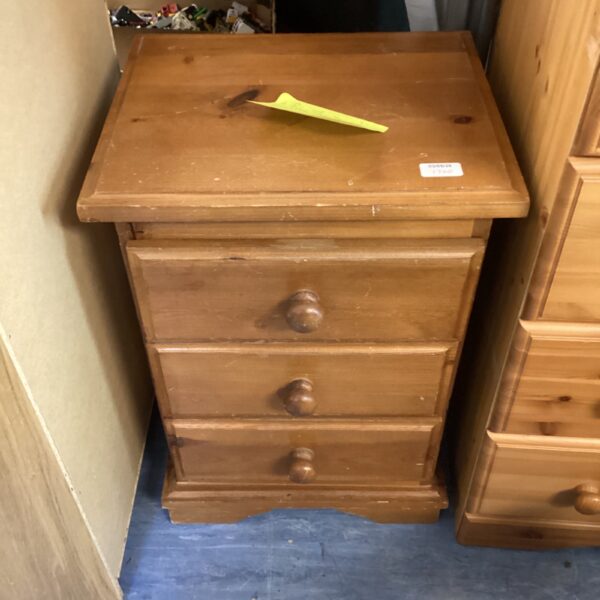 Vintage pine three-drawer cabinet with wooden knobs.