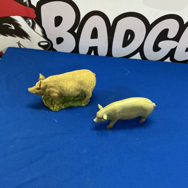 Vintage porcelain pig figurines, collectible animal decor.