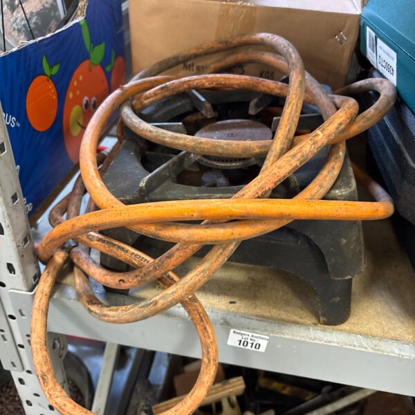 Two vintage propane camping stoves with flexible hoses.