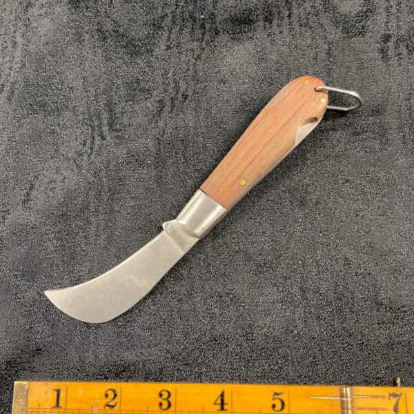 Vintage pruning knife with wooden handle for garden use.