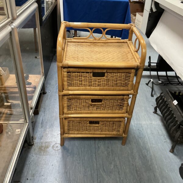 Vintage raffia storage unit with three drawers, natural woven texture.
