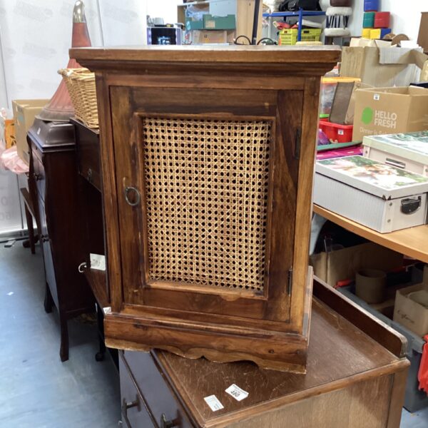 Vintage wooden cabinet with rattan door for farmhouse style.