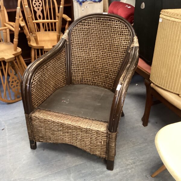 Vintage rattan conservatory chair with woven detail.