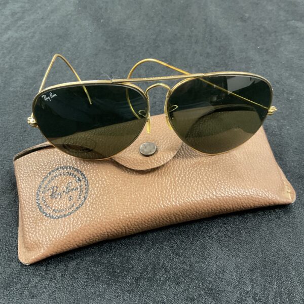 Gold Ray Ban aviator sunglasses displayed with case.