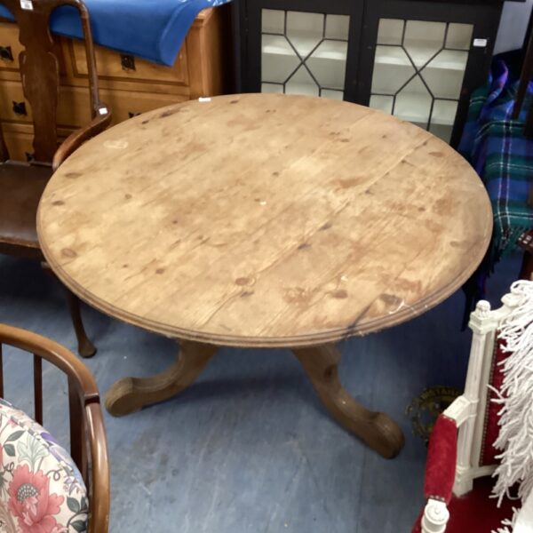 Vintage round pine dining table in a room setting.
