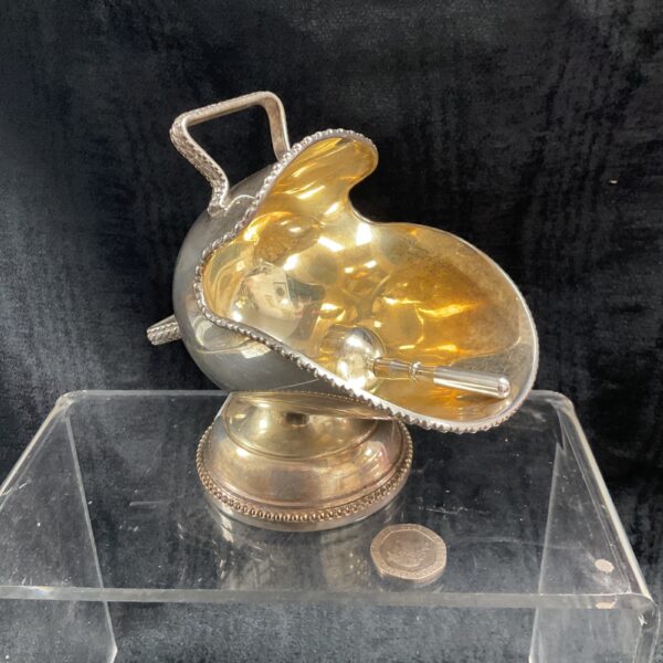 Vintage silver plated sugar scuttle with decorative handle.