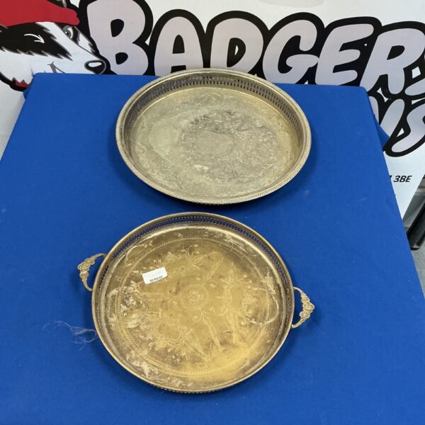 Vintage silverplate serving trays with ornate embossed designs.