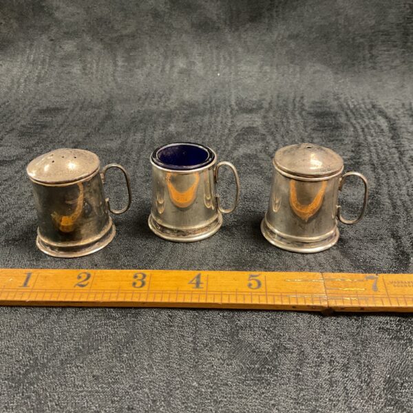 Vintage silverplate tankard cruet set for serving condiments.