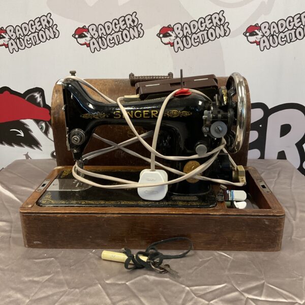 Vintage Singer sewing machine with treadle base, antique collectible.