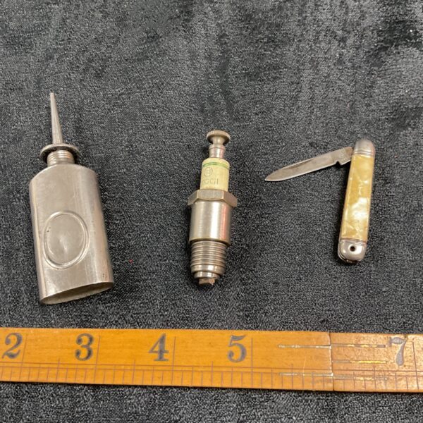Vintage spark plug lighter set with pocket knife and oil can.