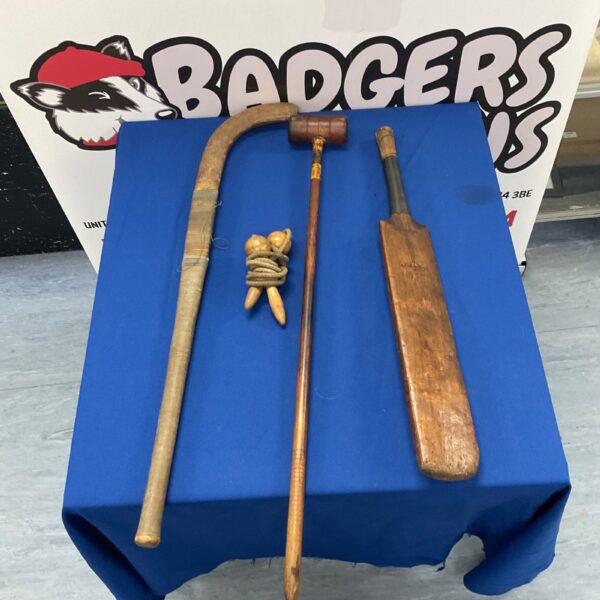 Vintage sports equipment lot including cricket bat and hockey stick.